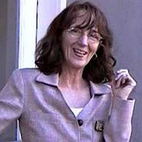 Lori Schultz Smiling woman with glasses and shoulder-length dark hair